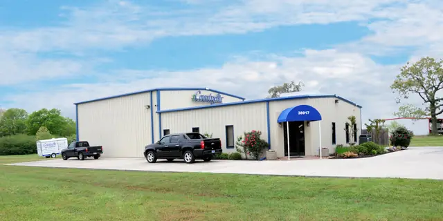 The Country Air shop on FM 1774 in Magnolia, a cream steel building with blue trim and a blue door awning